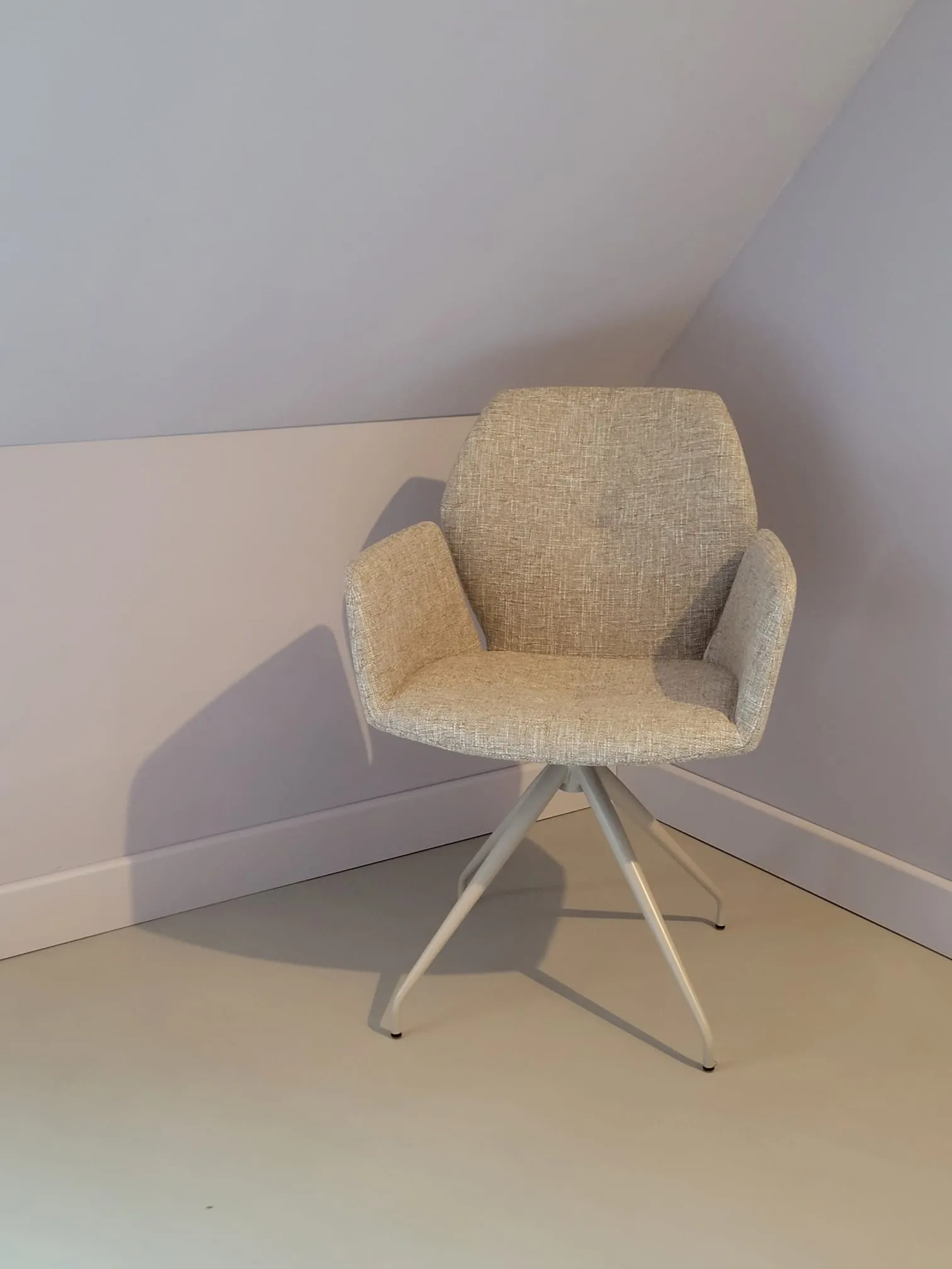 Designstoel op gietvloer onder schuine kap