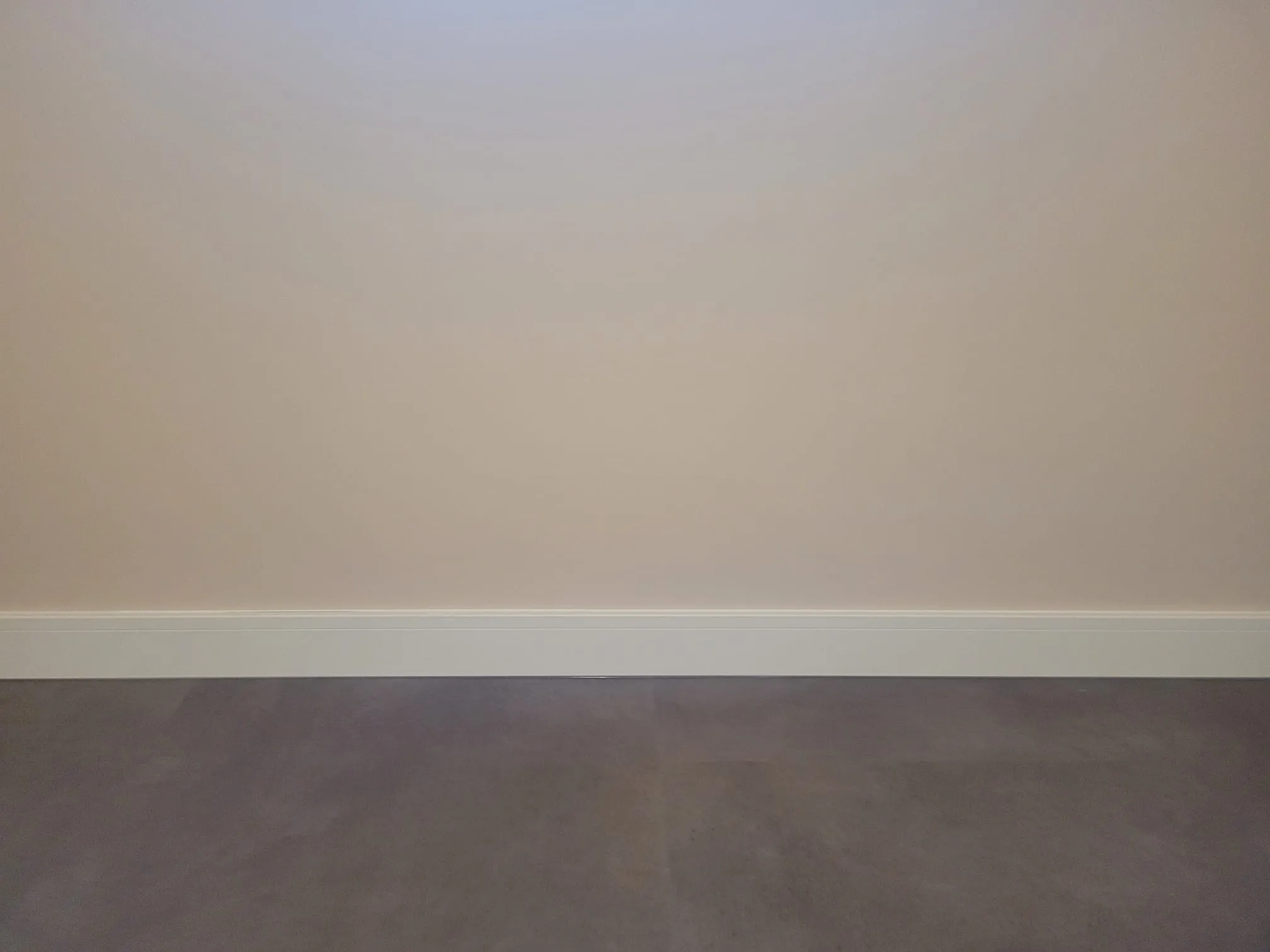 Lange wand met hoge witte plint en gietvloer